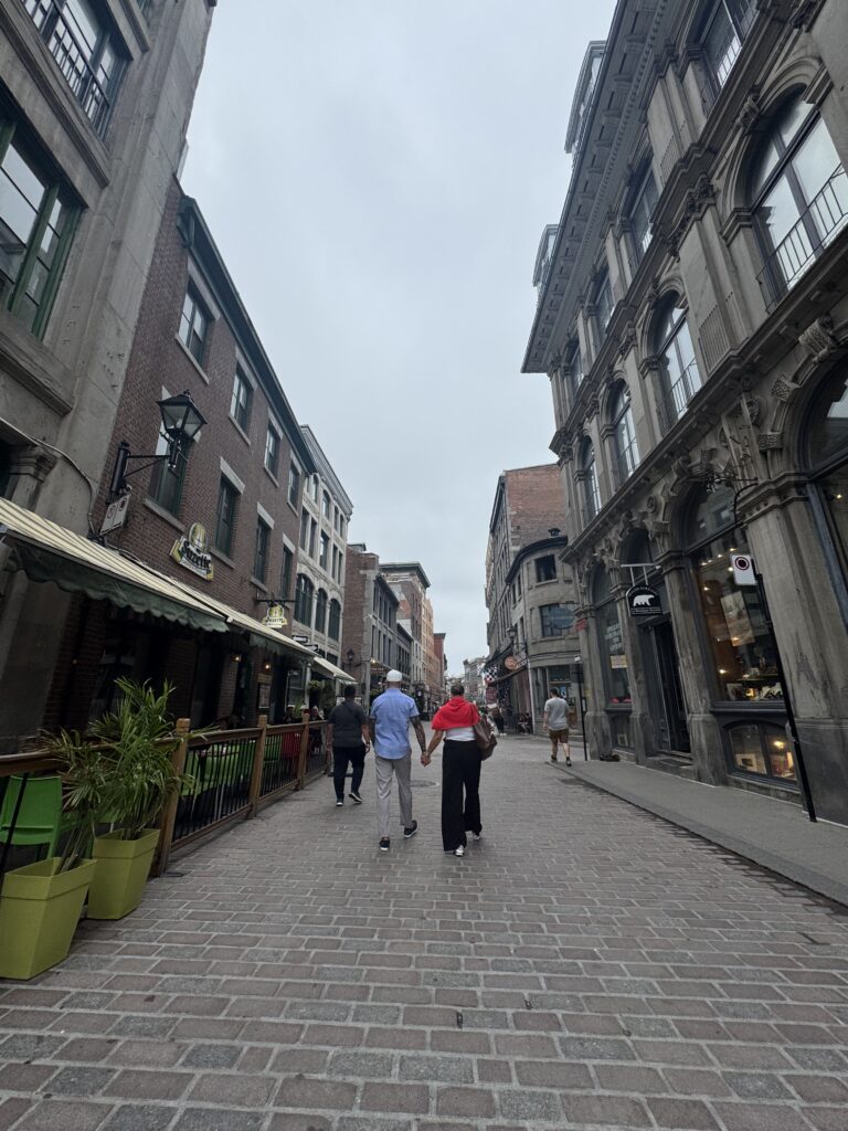 a couple holding hands walking at Plaque Jacque-Cartier