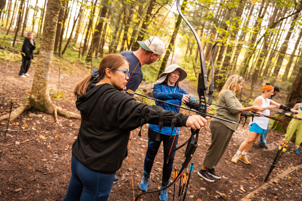 women holding bow and arrow learning archery