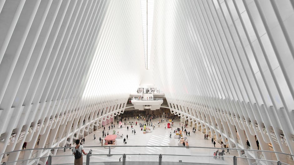 Symmetrical view of The Oculus interior, showcasing modern architecture and people in New York City.