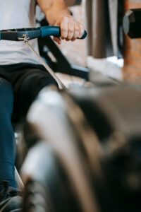 Close-up of a man rowing indoors, showcasing fitness and determination in a gym setting.