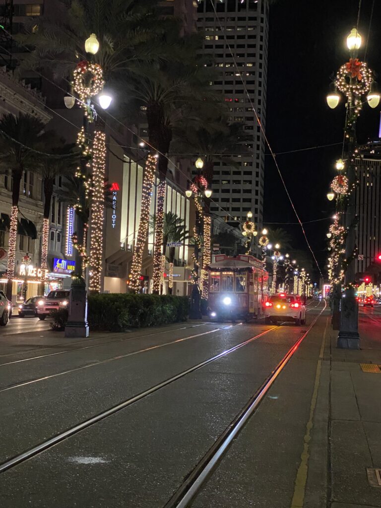 the red trolley on Canal Street surrounded by light posts with Christmas decorations