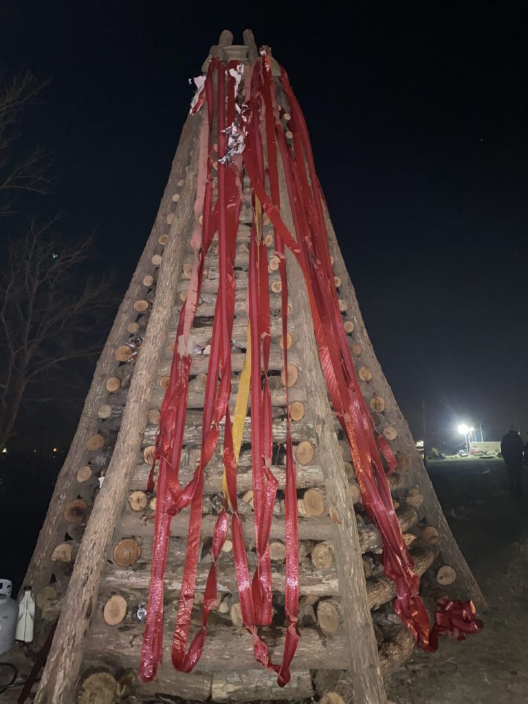 logs shaped into a pyramid with red ribbons