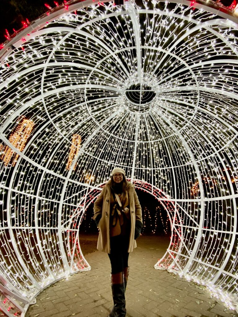 women standing inside a dome like structure decorated with white and red Christmas lights