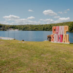 Camp Social sign with a lake in the background